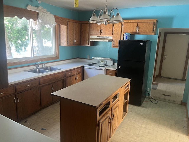 kitchen with a center island, pendant lighting, black fridge, electric range, and sink