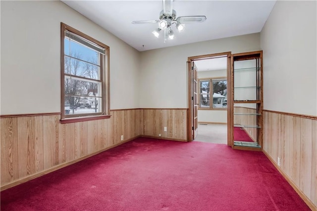 carpeted spare room featuring ceiling fan