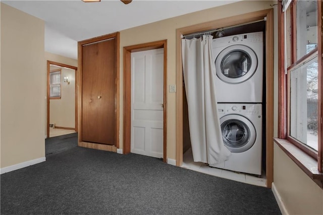 washroom featuring dark carpet and stacked washer and dryer