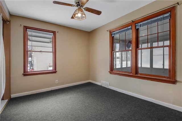 spare room featuring ceiling fan, a healthy amount of sunlight, and carpet flooring