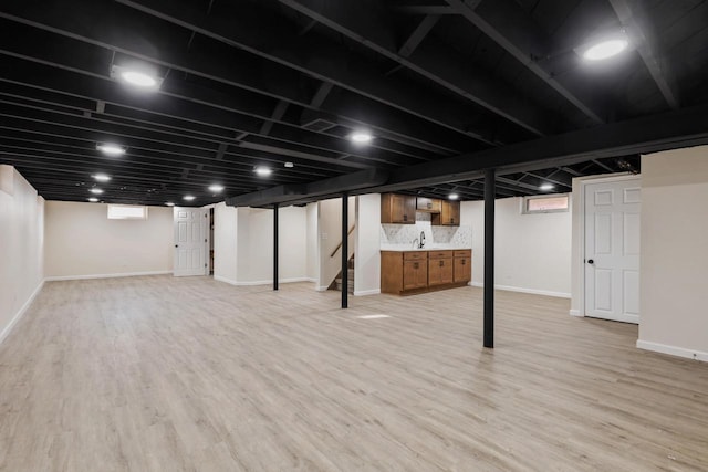 basement with sink and light wood-type flooring