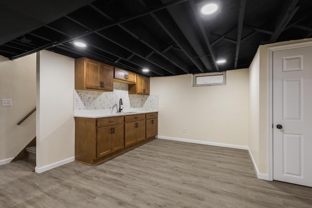 kitchen featuring decorative backsplash, sink, and light wood-type flooring