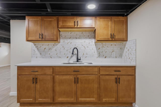 kitchen featuring light hardwood / wood-style floors, backsplash, and sink