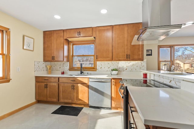 kitchen with backsplash, sink, island exhaust hood, light stone countertops, and appliances with stainless steel finishes