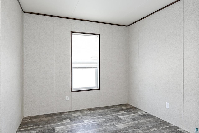 spare room featuring wood-type flooring and ornamental molding