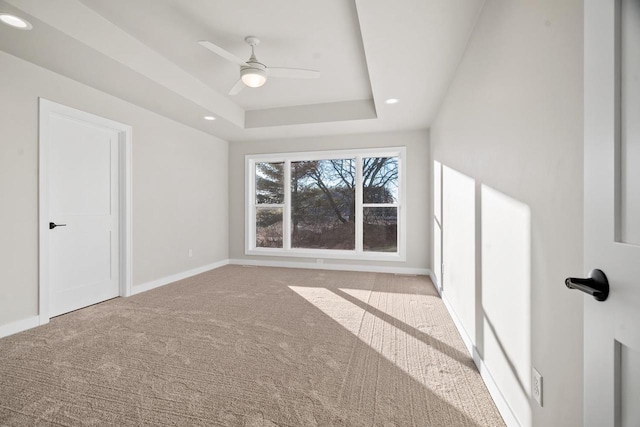 interior space with a raised ceiling and ceiling fan