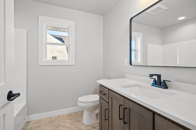 bathroom featuring toilet, a healthy amount of sunlight, and vanity