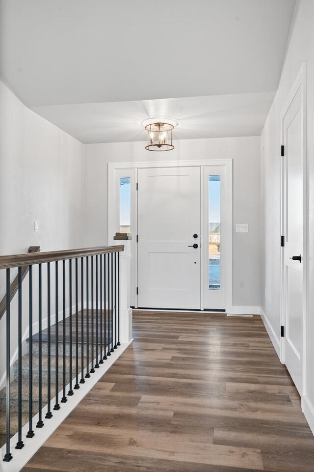 entrance foyer featuring dark hardwood / wood-style flooring and a notable chandelier