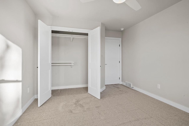 unfurnished bedroom with ceiling fan, a closet, and light colored carpet