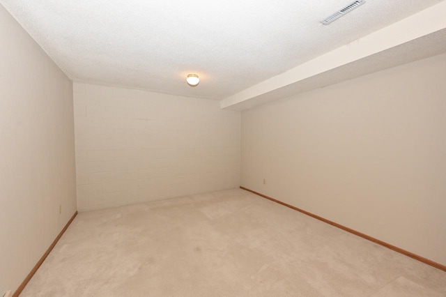 unfurnished room with light colored carpet and a textured ceiling