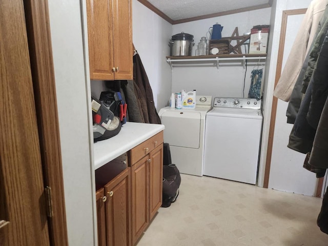 laundry area with cabinets, crown molding, and washer and clothes dryer