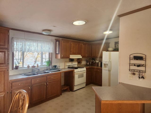 kitchen with ornamental molding, sink, kitchen peninsula, and white appliances