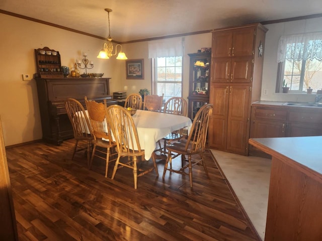 dining area with a chandelier, dark hardwood / wood-style flooring, and ornamental molding