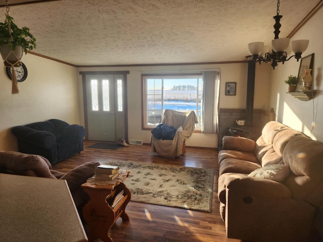 living room featuring a textured ceiling, crown molding, a wood stove, and wood-type flooring