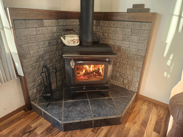 interior details with a wood stove and wood-type flooring