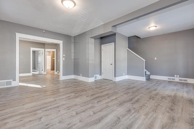 spare room featuring a textured ceiling and light hardwood / wood-style flooring