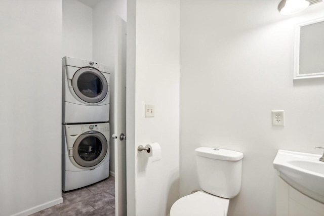 laundry room featuring stacked washer / drying machine and sink