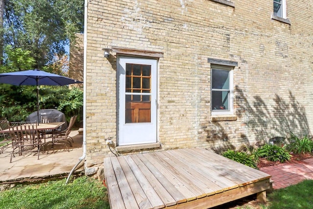 entrance to property with a deck and a patio