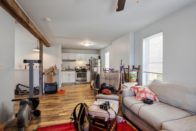 living room with light hardwood / wood-style floors, sink, and ceiling fan