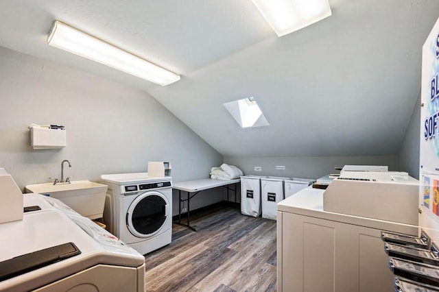 laundry area featuring a skylight, washer and dryer, dark hardwood / wood-style flooring, and sink