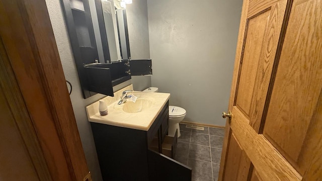 bathroom with vanity, toilet, and tile patterned floors