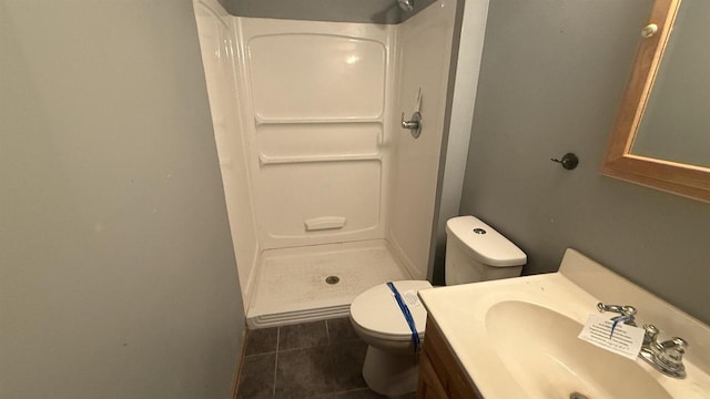 bathroom with toilet, tile patterned flooring, walk in shower, and vanity