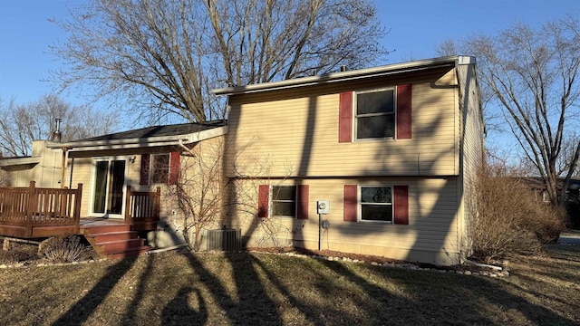 rear view of house featuring a wooden deck, a yard, and central AC