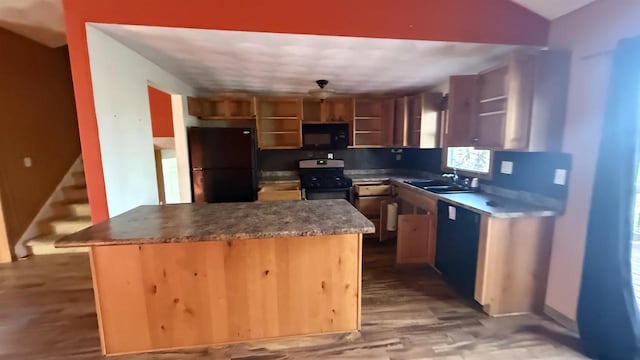 kitchen with black appliances, a center island, decorative backsplash, light wood-type flooring, and sink