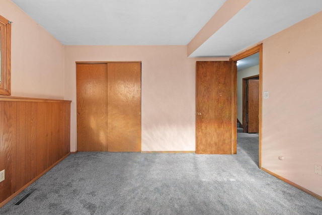 unfurnished bedroom featuring a closet and light colored carpet