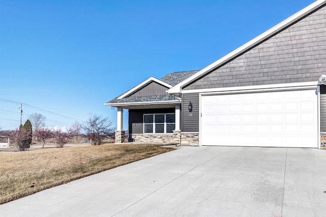 view of front of house with a garage, a front lawn, and covered porch