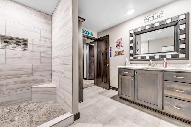 bathroom with tile patterned floors, tiled shower, and vanity