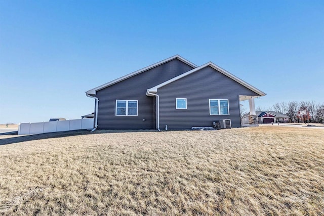 back of house featuring central AC unit and a yard