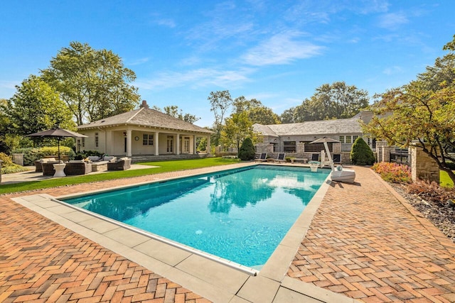 view of pool featuring an outbuilding and a patio area