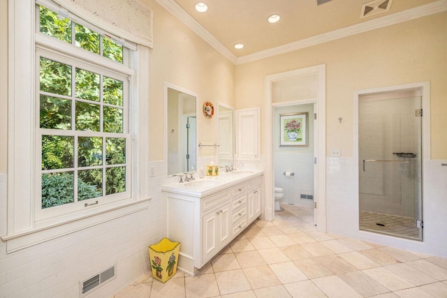 bathroom with tile walls, tile patterned flooring, toilet, a shower with door, and crown molding