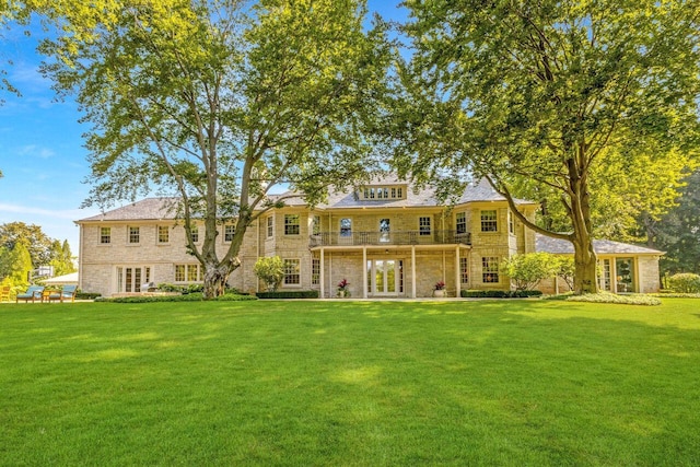 back of property with a yard and french doors