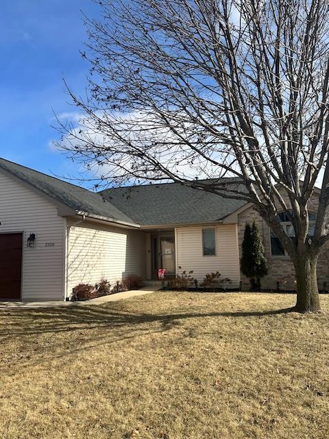 single story home featuring a front yard and an attached garage