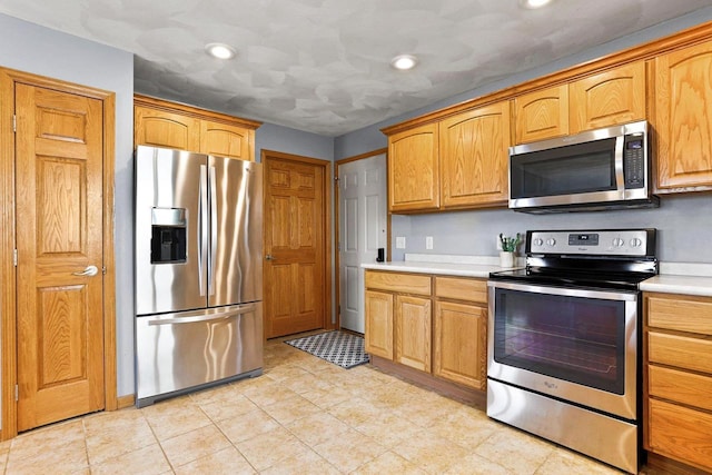 kitchen with recessed lighting, appliances with stainless steel finishes, and light countertops