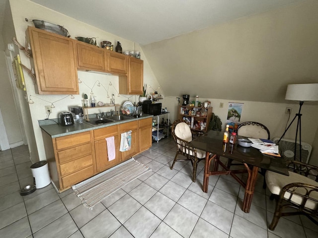 kitchen featuring sink, light tile patterned floors, and vaulted ceiling