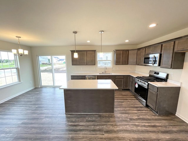 kitchen with sink, hanging light fixtures, a center island, and stainless steel appliances