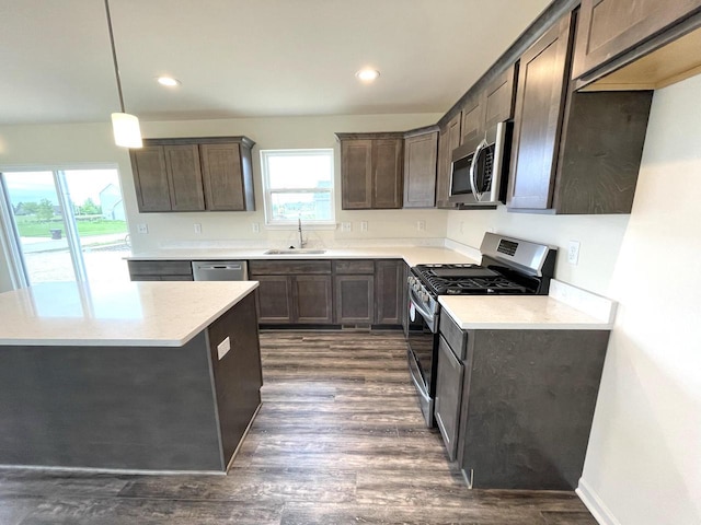 kitchen with a wealth of natural light, pendant lighting, sink, and stainless steel appliances