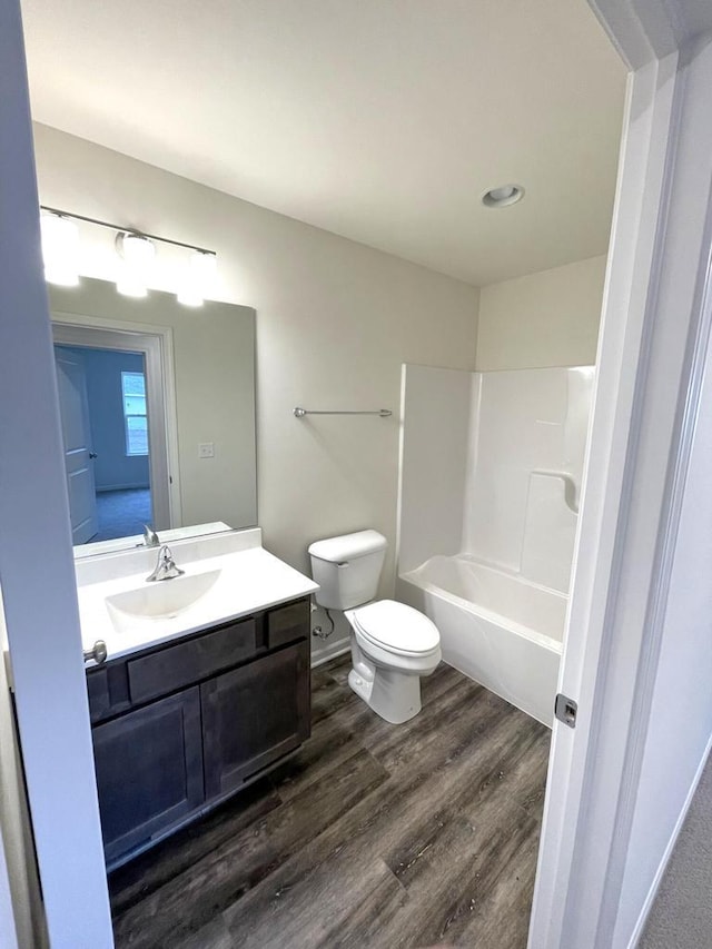 full bathroom featuring hardwood / wood-style flooring, toilet, vanity, and bathing tub / shower combination