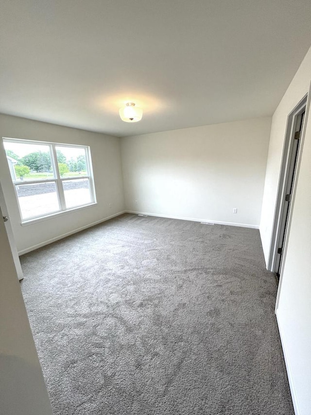 unfurnished room with dark colored carpet