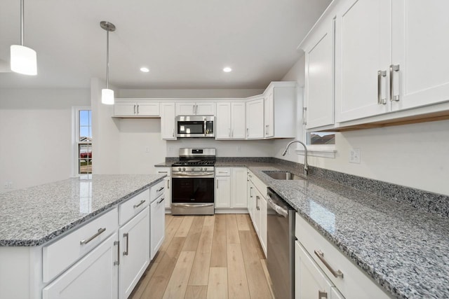 kitchen featuring sink, decorative light fixtures, white cabinetry, and appliances with stainless steel finishes