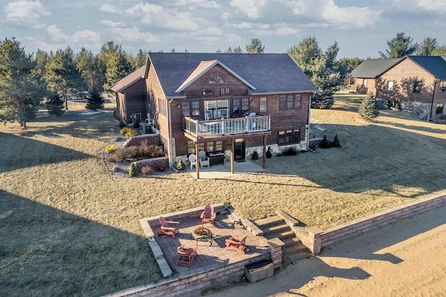 view of front facade featuring a front yard, a fire pit, a deck, and a patio