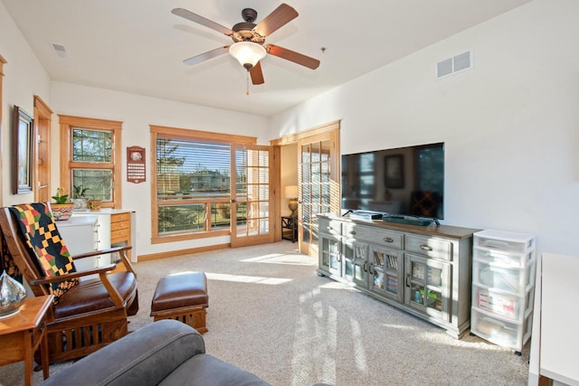 living room featuring light colored carpet and ceiling fan