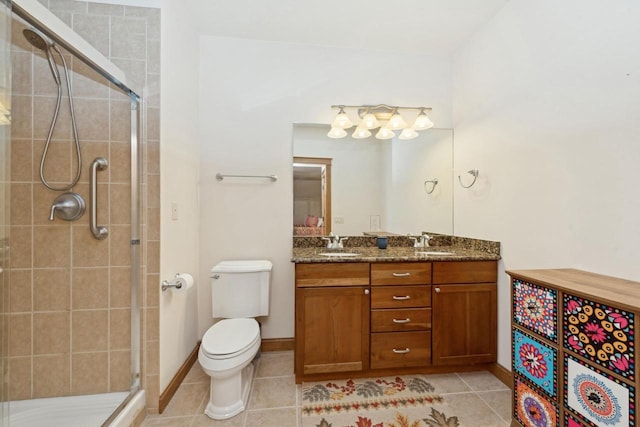 bathroom with vanity, toilet, tile patterned floors, and a shower with door