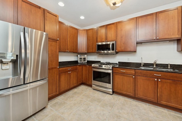 kitchen featuring sink, stainless steel appliances, and dark stone counters