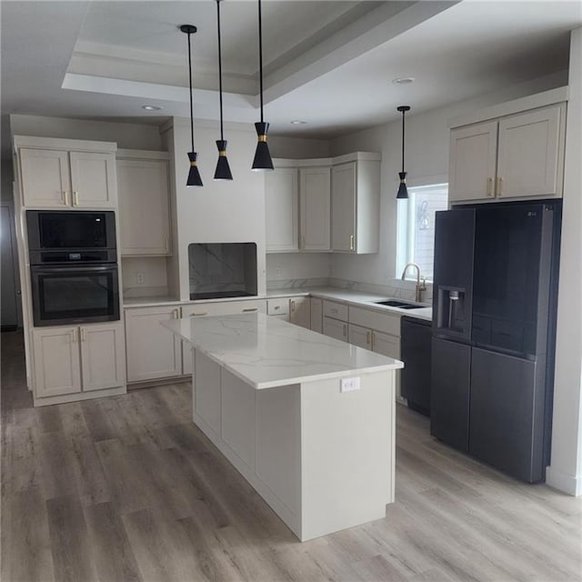 kitchen featuring white cabinets, black appliances, a raised ceiling, and a kitchen island