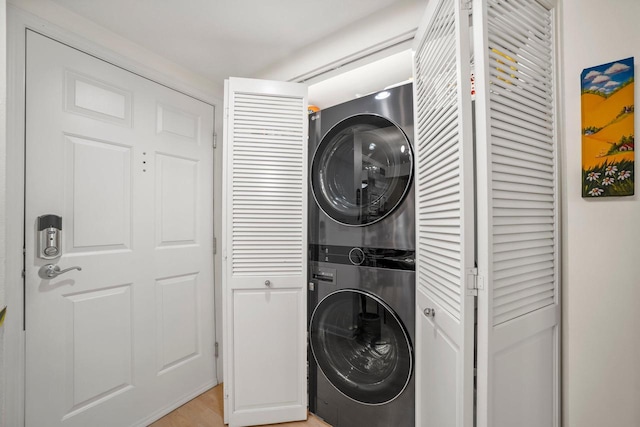 clothes washing area featuring stacked washer and clothes dryer