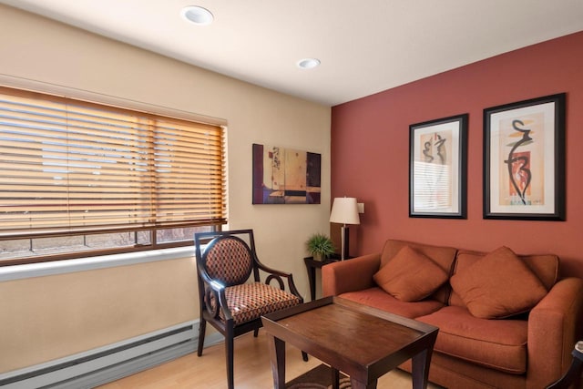 living room featuring a baseboard heating unit and light hardwood / wood-style flooring